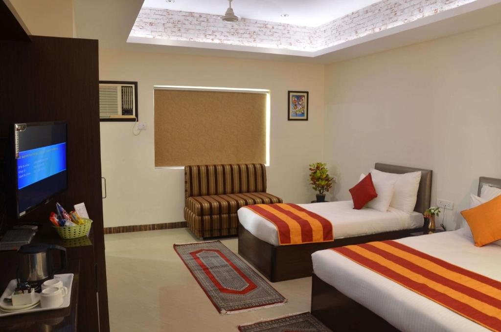 Deluxe room at Hotel Karan Vilas Agra showing larger layout, seating chairs, and window light