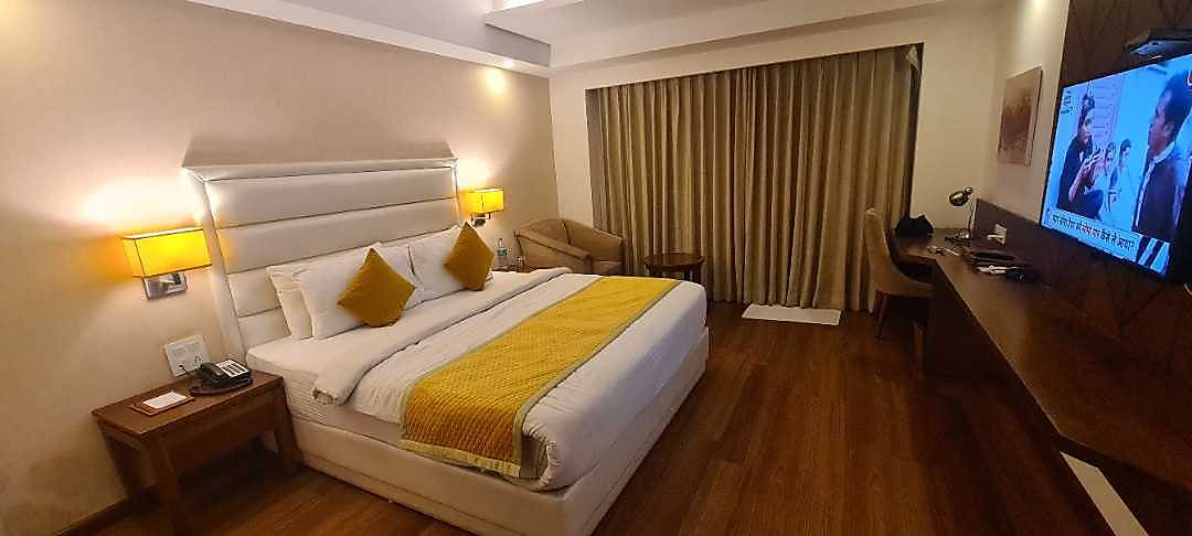 a bed with a yellow blanket and a chair in a room