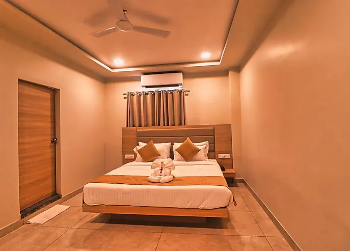 Deluxe room at Clarks Inn Express Udaipur with double bed, seating chair, and soft lighting