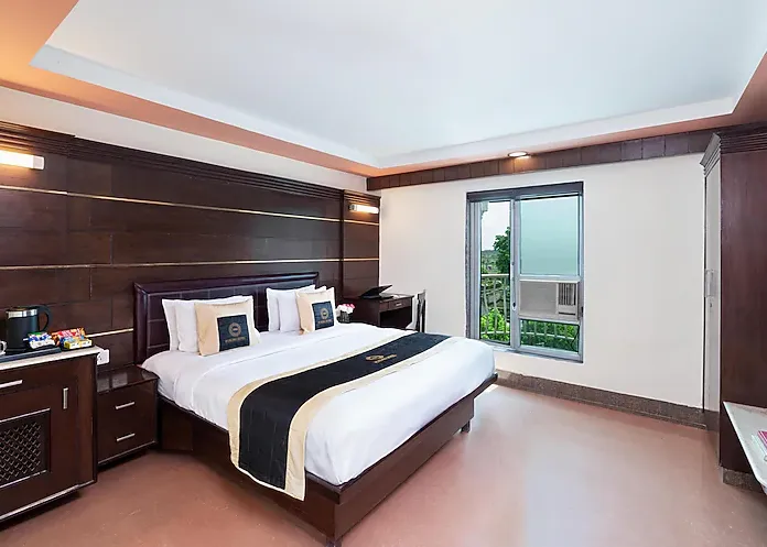 Premium room at Foxoso Taj View Agra with double bed, side tables, and neutral interior décor