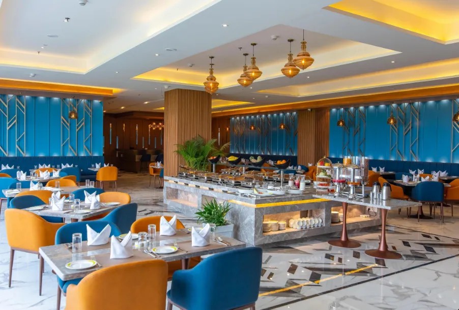 Restaurant at Hometel Alambagh Lucknow showing dining tables, chairs, and organised layout