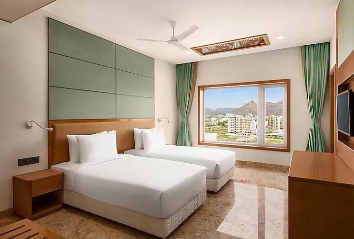 Deluxe room at Howard Johnson by Wyndham Udaipur showing spacious bed and window lighting