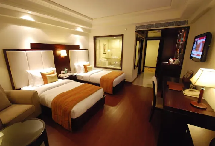 Deluxe guest room at Park Plaza Jodhpur showing bed, seating area, and ample natural light