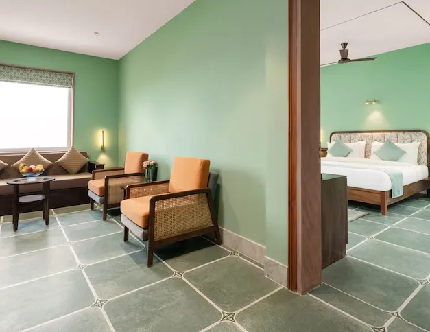 Suite room at Raasvan Vrindavan AM Hotel Kollection Vrindavan with separate seating and designer interiors