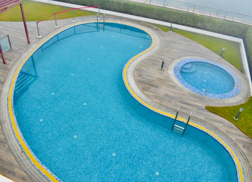 Swimming pool at Ramada By Wyndham Aligarh GT Road Agra with clear water, tiled deck, and surrounding seating