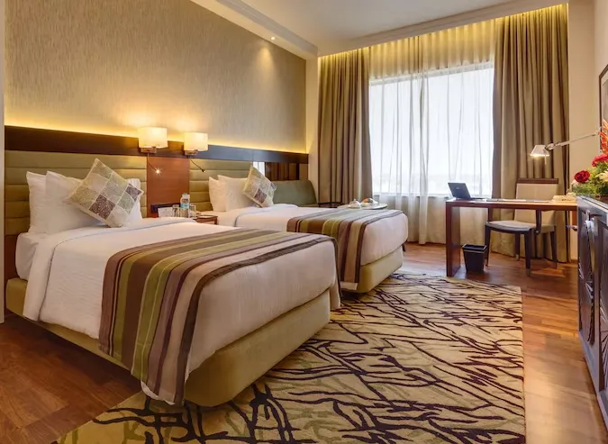 Deluxe room at Balaji Sarovar Premiere Solapur showing large bed and work desk