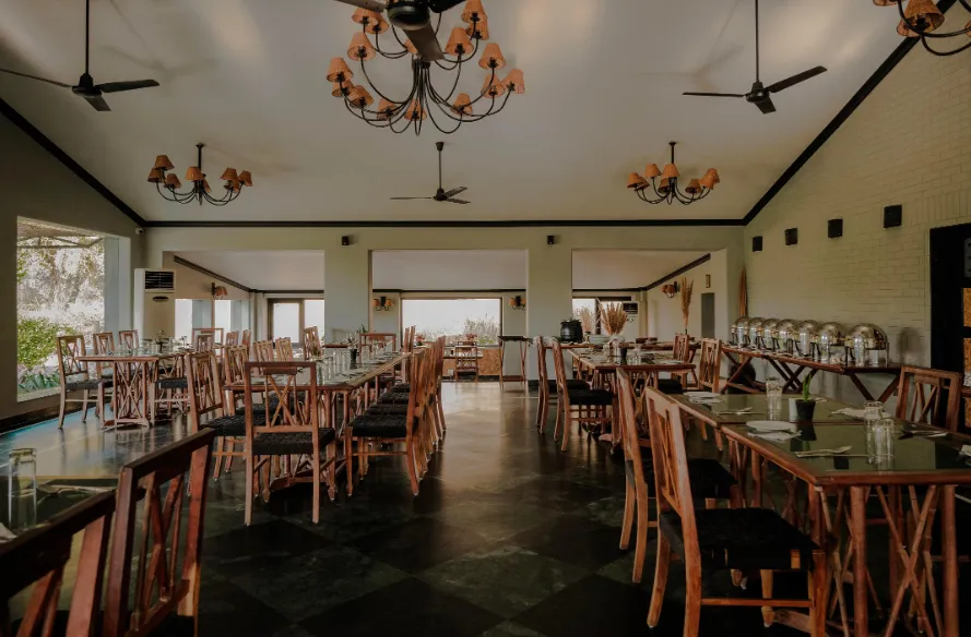 Restaurant at Clarks Safari Pushkar with dining tables set and warm ambience
