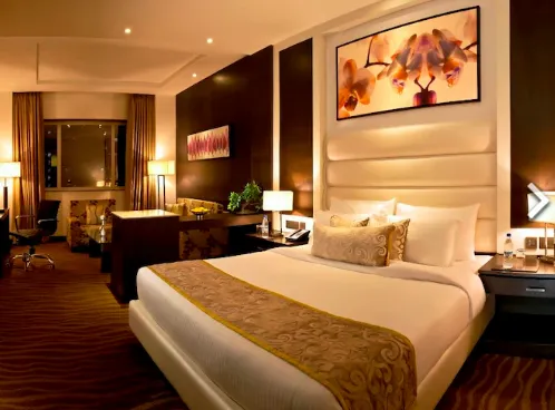Suite room at Golden Tulip BDI Club And Suites Bhiwadi with bed and sitting space