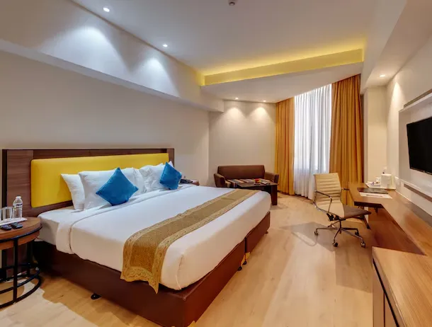 Deluxe room at Hotel Amarpreet Aurangabad showing large bed and seating
