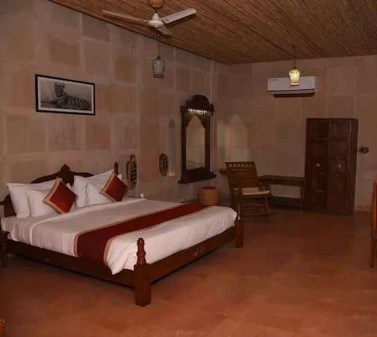Deluxe room at Puratan Qila Ranthambore featuring bed, seating, and natural lighting