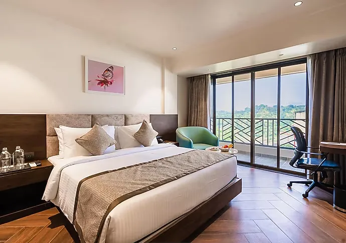 Deluxe room interior at Regenta Place Igatpuri with large window and seating area