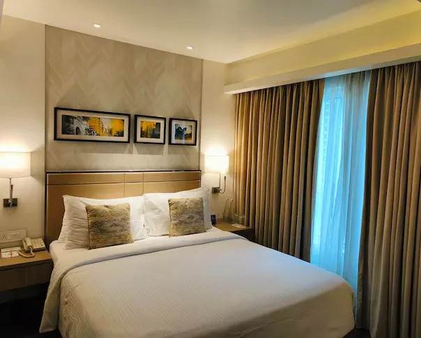 Superior room at Royal Hometel Suites Dahisar with tidy bed and work desk