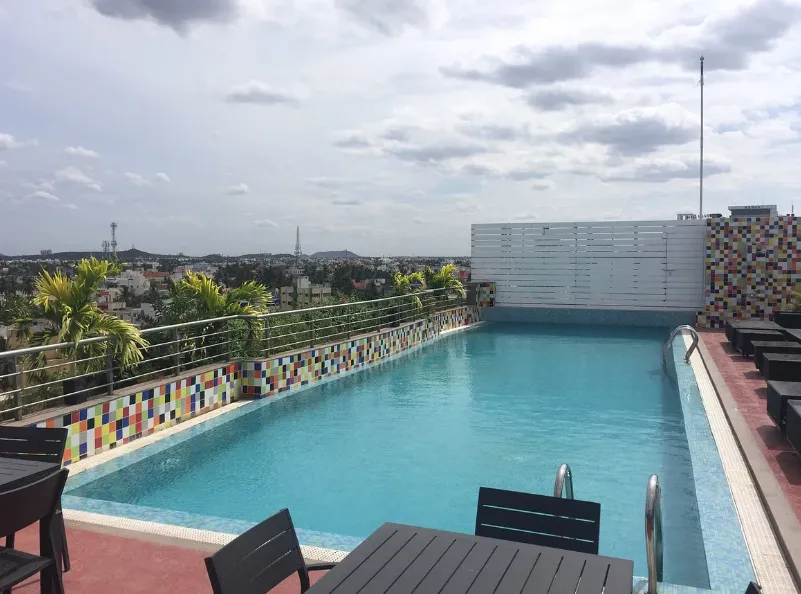 Swimming pool at Zone by The Park Hotel Chennai with deck chairs and clear blue water